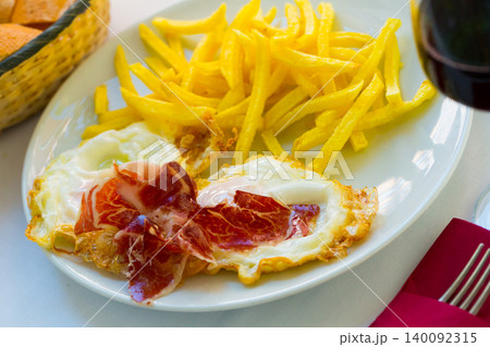 Fried eggs with ham, potatoes and wine Fried eggs with ham, potatoes and wine 140092315