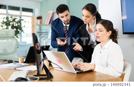 Group of qualified employees help a female intern work on a laptop Group of qualified employees help a female intern work on a laptop 140092341