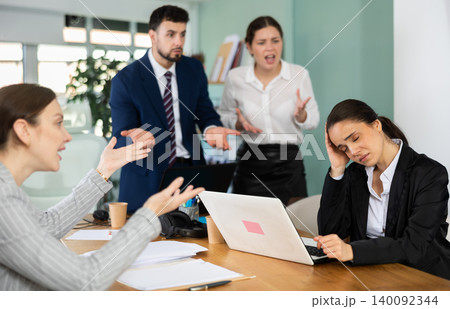 Group of colleagues scolding sad woman in office 140092344