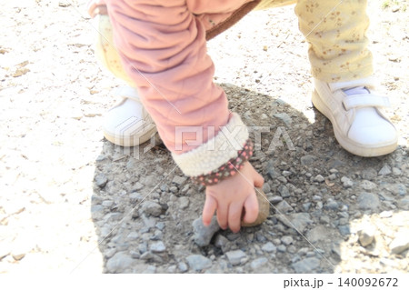 砂遊びをする幼児　石を拾う子供の画像 140092672