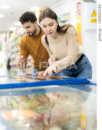 Young couple choosing frozen food in grocery store Young couple choosing frozen food in grocery store 140093249