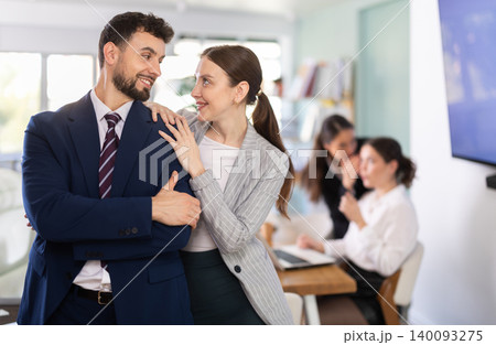 Young woman flirts with male colleague in office Young woman flirts with male colleague in office 140093275