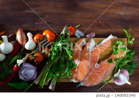 Vegetables, steaks of salmon, mushrooms on wooden background Vegetables, steaks of salmon, mushrooms on wooden background 140093340