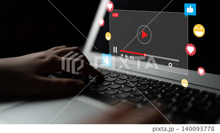 Person Engaging with Live Streaming Content on Laptop with Interactive Elements and Social Media Reactions in Dark Background Ledger 140093778