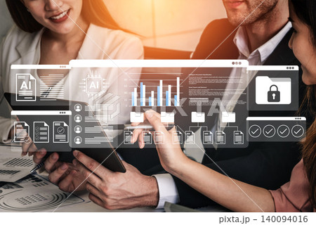 Business professionals discussing data analytics and artificial intelligence concepts in a modern workspace with virtual interfaces and graphs displayed. Gantry 140094016