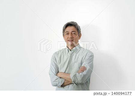 カメラ目線で微笑む腕組みをした60代の男性 カメラ目線で微笑む腕組みをした60代の男性 140094177