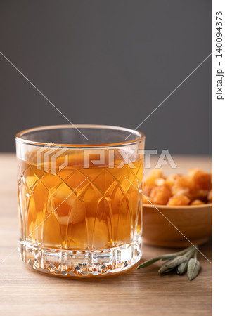 Longan juice in glass with dried longan fruit on wooden background Longan juice in glass with dried longan fruit on wooden background 140094373