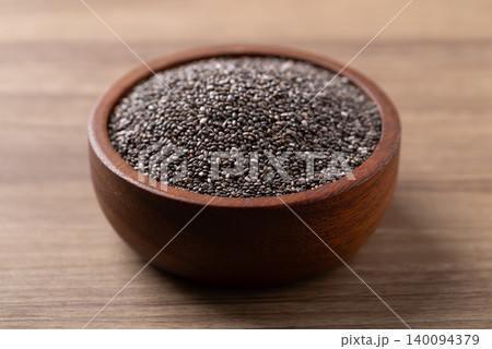 Healthy organic chia seeds in a wooden bowl on a wooden background Healthy organic chia seeds in a wooden bowl on a wooden background 140094379