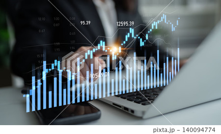 Business professional analyzing financial data on laptop with digital charts showing market trends and stock performance in an office setting Scalp 140094774