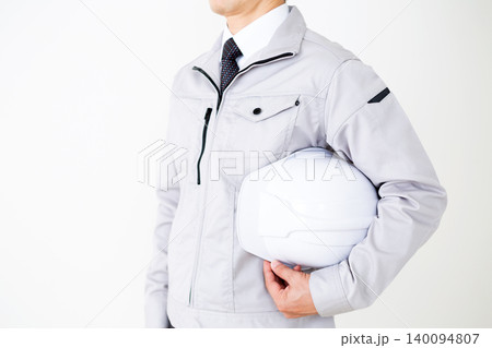 ヘルメットを持つグレーの作業着のミドル男性ビジネスマン白バック ヘルメットを持つグレーの作業着のミドル男性ビジネスマン白バック 140094807