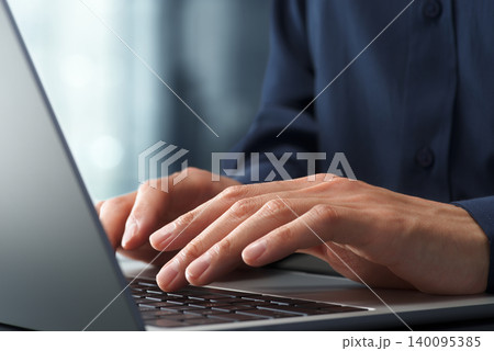 オフィスのデスクでノートパソコンを使うビジネスパーソン。手とキーボードのクローズアップ。ビジネスでの オフィスのデスクでノートパソコンを使うビジネスパーソン。手とキーボードのクローズアップ。ビジネスでの 140095385