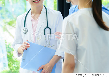 病院で打ち合わせをする医師と看護師 病院で打ち合わせをする医師と看護師 140097040