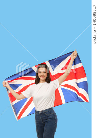 Young woman waves British flag joyfully. Celebration and cultural identity concept Young woman waves British flag joyfully. Celebration and cultural identity concept 140098317