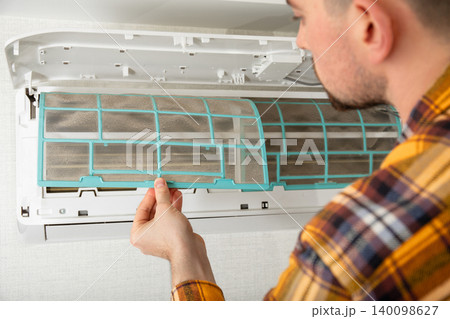 Air conditioner technician inspects cooling system indoors 140098627