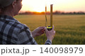 Agronomist with ruler in wheat field. Woman measures crop to check crop quality and crop readiness. Quality control supports modern crop production. Agronomist inspects wheat field 140098979