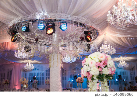 Elegant banquet hall decorated for wedding with chandeliers and floral arrangements 140099066