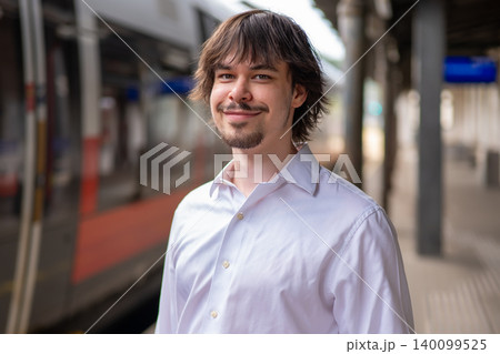 Positive portrait of young man with beard at railway station in Austria. Positive portrait of young man with beard at railway station in Austria. 140099525