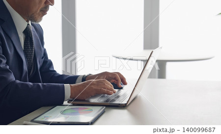 ノートパソコンとタブレットPCを使って作業する男性 ノートパソコンとタブレットPCを使って作業する男性 140099687