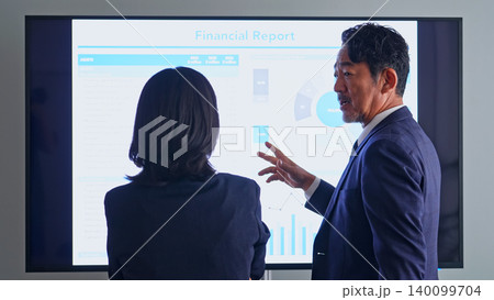 画面を見ながら会話するビジネスパーソンのグループ 画面を見ながら会話するビジネスパーソンのグループ 140099704