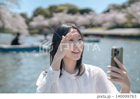 千鳥ヶ淵のボートで花見を楽しむ若い女性 スマホで自撮り 観光 デート 千鳥ヶ淵のボートで花見を楽しむ若い女性 スマホで自撮り 観光 デート 140099763