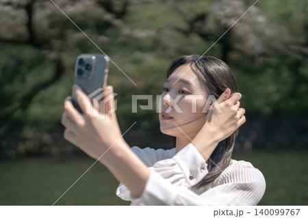 千鳥ヶ淵のボートで花見を楽しむ若い女性 スマホで自撮り 観光 デート 千鳥ヶ淵のボートで花見を楽しむ若い女性 スマホで自撮り 観光 デート 140099767