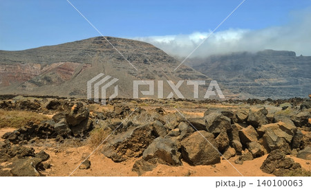 Wide view of Lanzarote desert landscape with volcanic hills and stark island beauty Wide view of Lanzarote desert landscape with volcanic hills and stark island beauty 140100063