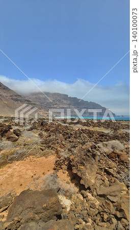 Wide view of Lanzarote desert landscape with volcanic hills and stark island beauty Wide view of Lanzarote desert landscape with volcanic hills and stark island beauty 140100073