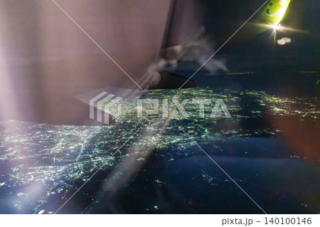羽田空港から那覇行の旅客機の窓。 上空1万メートルから見下ろす日本の夜景。東京都大田区東京国際空港 羽田空港から那覇行の旅客機の窓。 上空1万メートルから見下ろす日本の夜景。東京都大田区東京国際空港 140100146