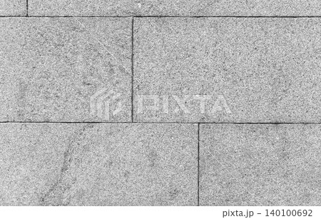 Close-up of a gray granite wall made of rectangular stone blocks 140100692