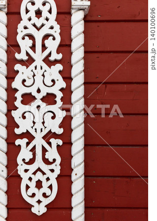 Carved white wooden trim with ornate scrollwork flanked by twisted columns Carved white wooden trim with ornate scrollwork flanked by twisted columns 140100696