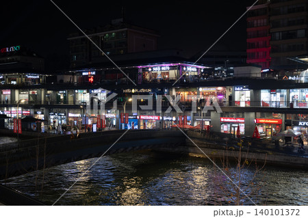 Tashkent, Uzbekistan - February 02, 2026: Seoul Mun Street. Rainy Evening with Neon Lights and People Walking. 140101372