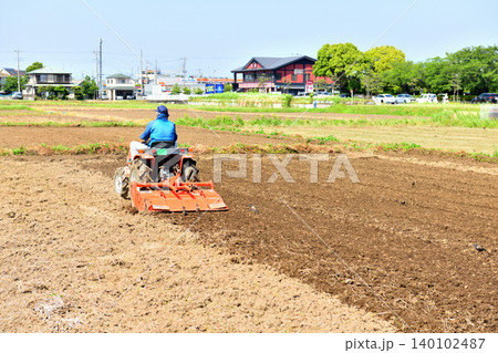 トラクターで田植えの準備をする男性 トラクターで田植えの準備をする男性 140102487