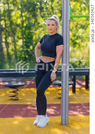 Young woman resting in outdoor fitness park during challenging workout session 140103427