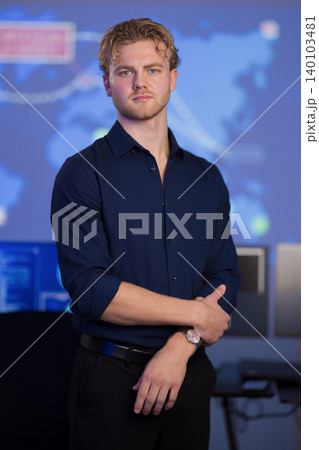 Confident male analyst in a control room with digital map background Confident male analyst in a control room with digital map background 140103481