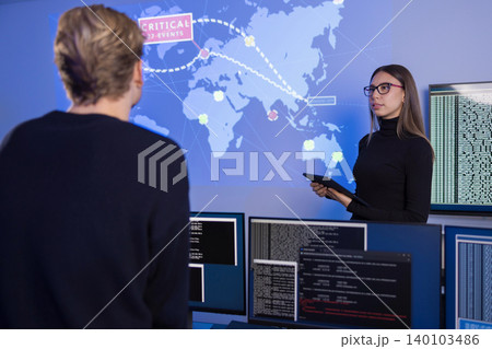 Team collaborating in a SOC monitoring critical cybersecurity events on a world map 140103486