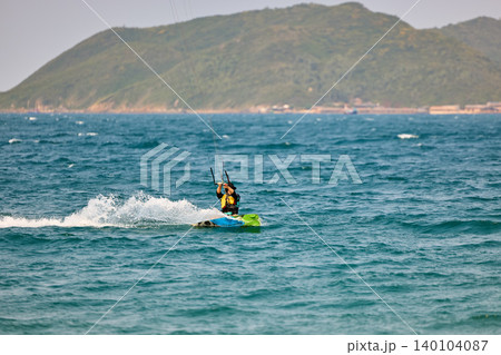 Nha Trang, Khanh Hoa - Vietnam - April 4, 2026: Kitesurfer Cutting Through Waves in Open Sea 140104087