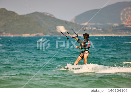 Nha Trang, Khanh Hoa - Vietnam - April 5, 2026: Kitesurfer Cutting Through Waves in Open Sea 140104105