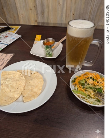 インド・ネパール料理店での食事風景(生ビールとパパド、サラダ) インド・ネパール料理店での食事風景(生ビールとパパド、サラダ) 140105086