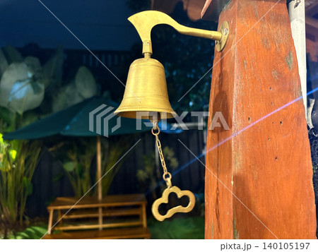 Antique brass bell hanging on outdoor pillar with ornamental, structure Antique brass bell hanging on outdoor pillar with ornamental, structure 140105197