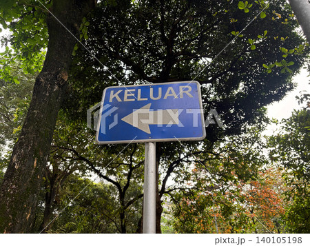 Blue keluar exit sign with left arrow in garden directional navigation 140105198