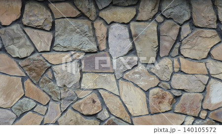 Decorative stone cladding for interiors or exteriors using natural, large, lightly processed stone. The beautiful texture of a stone mosaic with randomly arranged cobblestones. 140105572