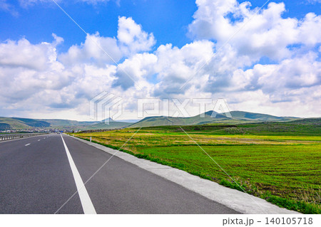 Open highway with lush green fields 140105718