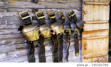 Old horse harnesses hang on a wooden wall in a stables during daytime showing signs of wear and age Old horse harnesses hang on a wooden wall in a stables during daytime showing signs of wear and age 140105768