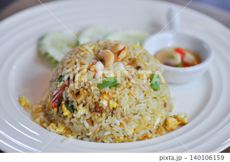 stir fried rice or fried rice  with cashew nut topping and cucumber 140106159
