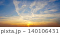 Sunset with clouds over a horizon during evening hours near a cityscape 140106431