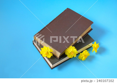 Yellow flowers bookmark at hardcover book. Yellow flowers bookmark at hardcover book. 140107102