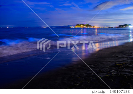 月明かりの七里ヶ浜と江の島夜景 夜光虫が青く輝く海とスローシャッターで白い雲が浮かぶ幻想風景 140107188