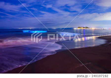 月明かりの七里ヶ浜と江の島夜景 夜光虫が青く輝く海とスローシャッターで白い雲が浮かぶ幻想風景 140107192