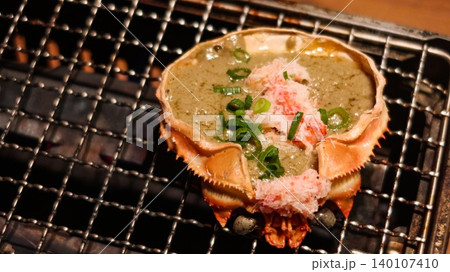 close up of grilled crab shell with kani miso, crab meat, and green onion garnish, which is a traditional Japanese seafood delicacy called Crab Miso on Shell on the stove with copy space close up of grilled crab shell with kani miso, crab meat, and green onion garnish, which is a traditional Japanese seafood delicacy called Crab Miso on Shell on the stove with copy space 140107410