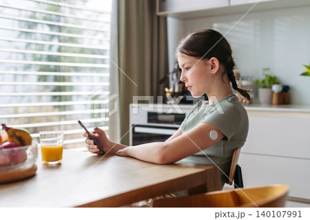 Teen girl with diabetes scanning glucose level using CGM sensor and smartphone. Teen girl with diabetes scanning glucose level using CGM sensor and smartphone. 140107991
